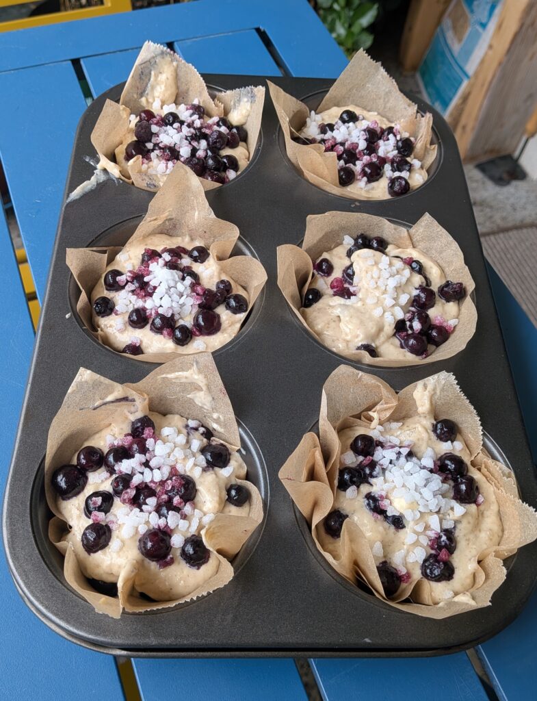 Blueberry Muffins Recipe – Method 2: Made with Butter, Freshly baked blueberry muffins made with butter, golden tops, juicy blueberries bursting inside, tender and fluffy crumb, muffins cooling on a wire rack, home-baked breakfast treat, natural light, food blog, muffin ideas, muffin recipes, blueberries recipes, baking with blueberries, baking recipes, easy muffin recipes, saru's diary, saru's not so secret diary