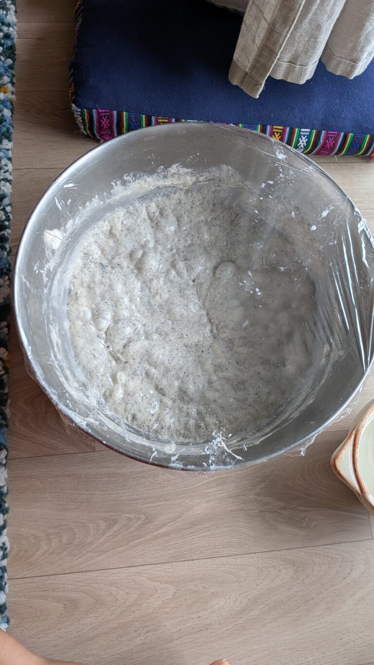 My No-Knead Artisan Bread With Black Sesame & Walnuts, Rustic no-knead black sesame bread on parchment paper, topped with poppy seeds and roasted sesame seeds, golden crust, airy texture, warm kitchen background, bread recipe, saru's diary, saru's not so secret diary, bread baking at home, homemade bread recipe
