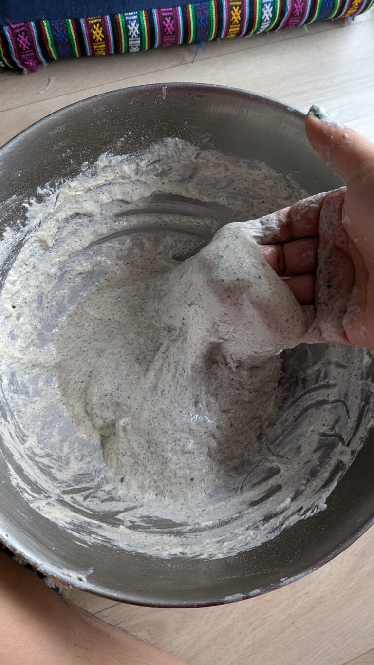 My No-Knead Artisan Bread With Black Sesame & Walnuts, Rustic no-knead black sesame bread on parchment paper, topped with poppy seeds and roasted sesame seeds, golden crust, airy texture, warm kitchen background, bread recipe, saru's diary, saru's not so secret diary, bread baking at home, homemade bread recipe