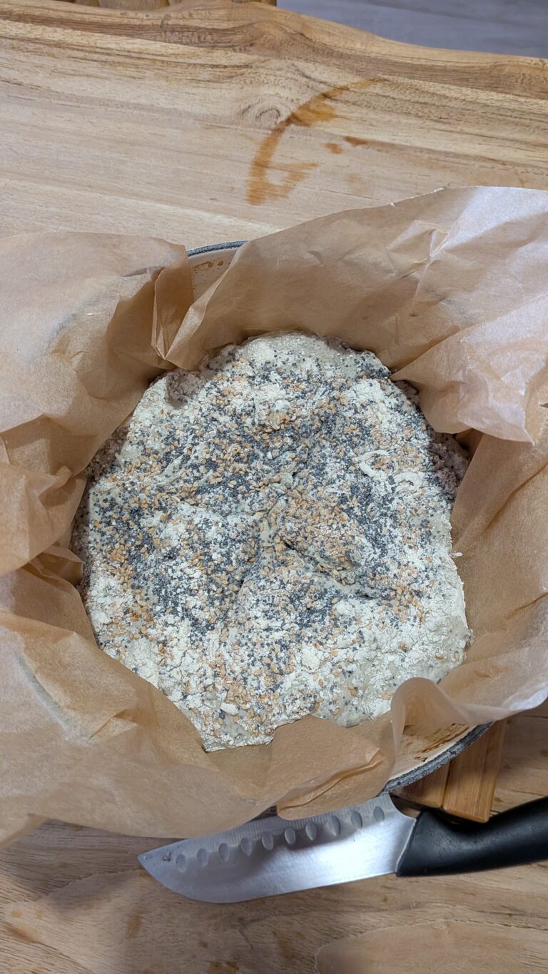 My No-Knead Artisan Bread With Black Sesame & Walnuts, Rustic no-knead black sesame bread on parchment paper, topped with poppy seeds and roasted sesame seeds, golden crust, airy texture, warm kitchen background, bread recipe, saru's diary, saru's not so secret diary, bread baking at home, homemade bread recipe