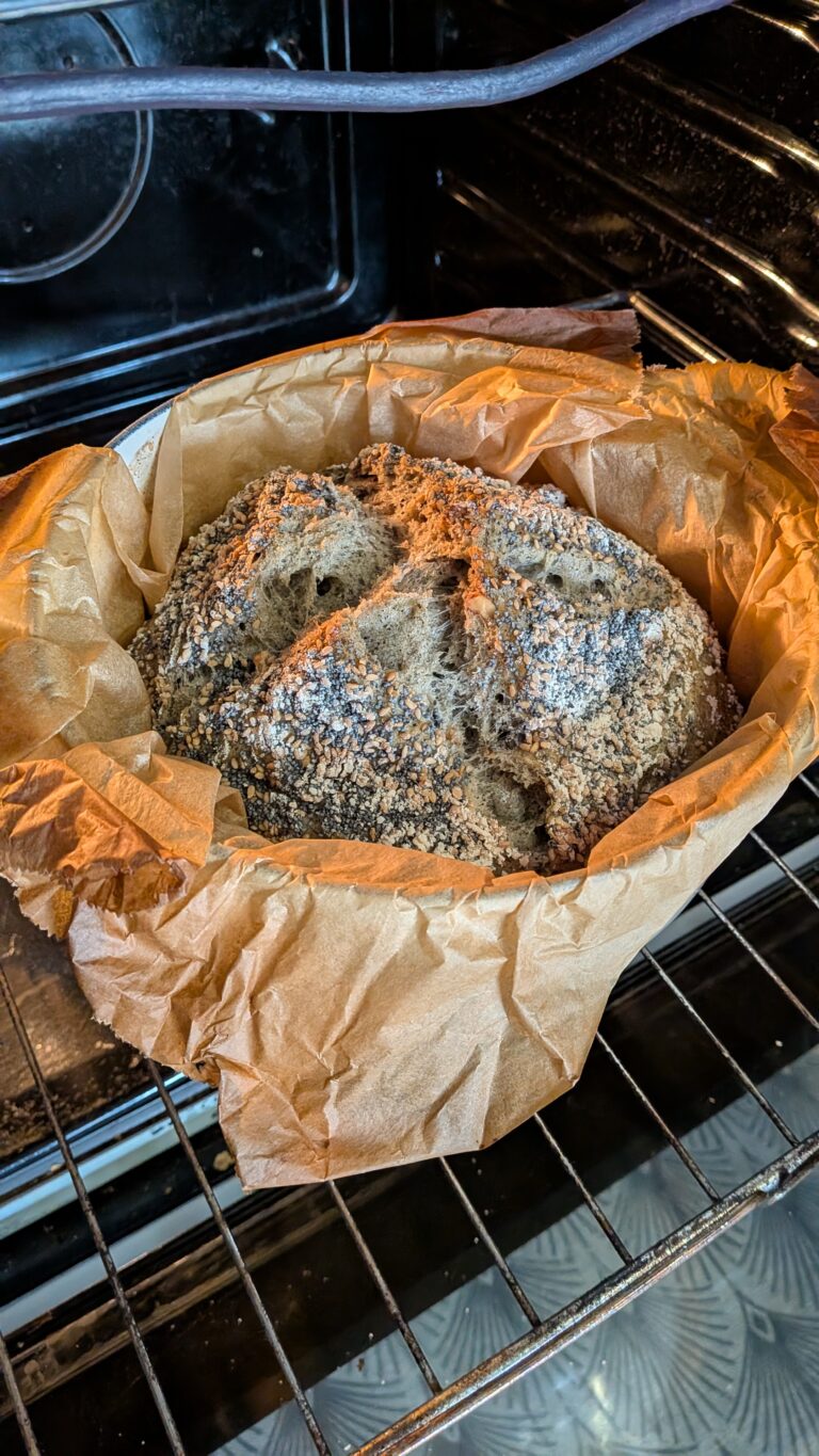 My No-Knead Artisan Bread With Black Sesame & Walnuts, Rustic no-knead black sesame bread on parchment paper, topped with poppy seeds and roasted sesame seeds, golden crust, airy texture, warm kitchen background, bread recipe, saru's diary, saru's not so secret diary, bread baking at home, homemade bread recipe