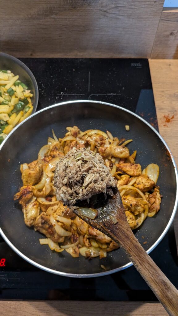 Nepali chicken curry in a traditional bowl with fresh cilantro and scallion garnish, Close-up of bone-in chicken pieces in thick tomato gravy, Step-by-step frying chicken in a heavy-bottomed pan with spices, Grinding ginger-garlic with powdered spices in a mortar and pestle, Adding tomatoes and ground spices to the chicken curry, Finished Nepali chicken curry served with steamed rice and roti, Garnishing chicken curry with fresh cilantro and scallions, Nepali Chicken Curry (Kukhura Ko Masu) – A Home-Style Recipe From My Roots, saru's diary, saru's not so secret diary, nepali food , nepali food blog, food around the world, chicken recipes around the world