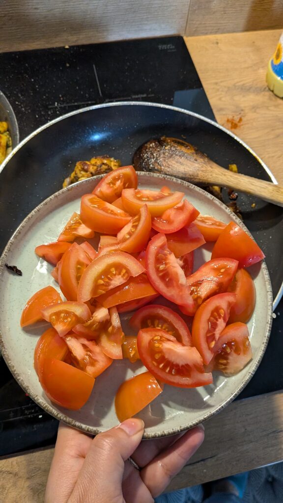 Nepali chicken curry in a traditional bowl with fresh cilantro and scallion garnish, Close-up of bone-in chicken pieces in thick tomato gravy, Step-by-step frying chicken in a heavy-bottomed pan with spices, Grinding ginger-garlic with powdered spices in a mortar and pestle, Adding tomatoes and ground spices to the chicken curry, Finished Nepali chicken curry served with steamed rice and roti, Garnishing chicken curry with fresh cilantro and scallions, Nepali Chicken Curry (Kukhura Ko Masu) – A Home-Style Recipe From My Roots, saru's diary, saru's not so secret diary, nepali food , nepali food blog, food around the world, chicken recipes around the world
