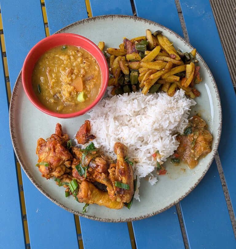 Nepali chicken curry in a traditional bowl with fresh cilantro and scallion garnish, Close-up of bone-in chicken pieces in thick tomato gravy, Step-by-step frying chicken in a heavy-bottomed pan with spices, Grinding ginger-garlic with powdered spices in a mortar and pestle, Adding tomatoes and ground spices to the chicken curry, Finished Nepali chicken curry served with steamed rice and roti, Garnishing chicken curry with fresh cilantro and scallions, Nepali Chicken Curry (Kukhura Ko Masu) – A Home-Style Recipe From My Roots, saru's diary, saru's not so secret diary, nepali food , nepali food blog, food around the world, chicken recipes around the world